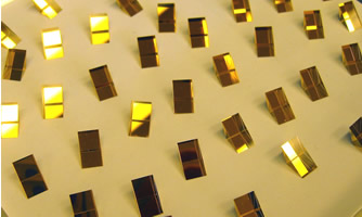 Small gold coated prisms lined up for QA inspection. Image for gold-coated-prismsjpg
